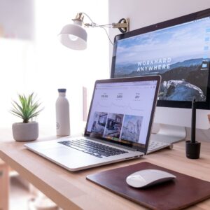 MacBook Pro on table beside white iMac and Magic Mouse